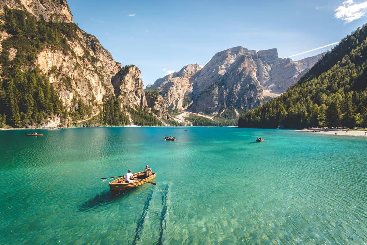 A rowboat resting on an emerald mountain lake